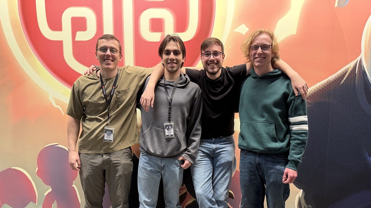 Group of people posing in front of a mural