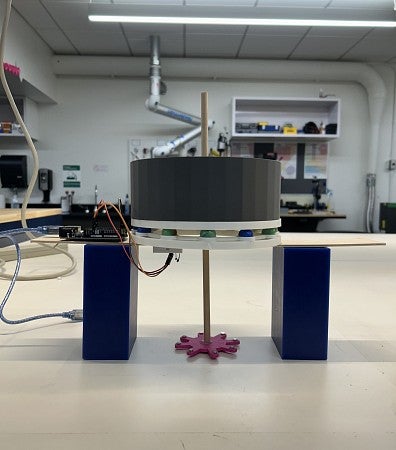 A device with a wheel and a gear on sitting on a tabletop
